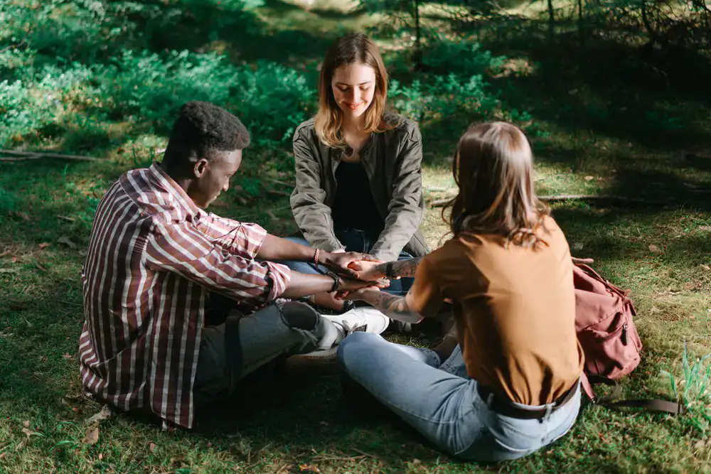 Colleagues sitting in a circle in a forest clearing